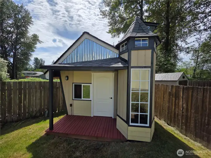 Playhouse or office? Check out the cool turret and roof.
