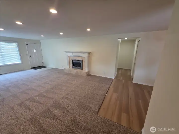 The hallway goes to the great room and the primary bedroom with 3/4 bath. To the right is the dining room and kitchen.