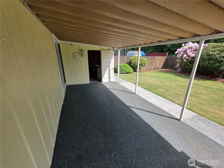 view of back patio from dining room door. Keep dry in the rain or in the shade on a summer day. Storage shed attached to house as well. It includes a beverage fridge.
