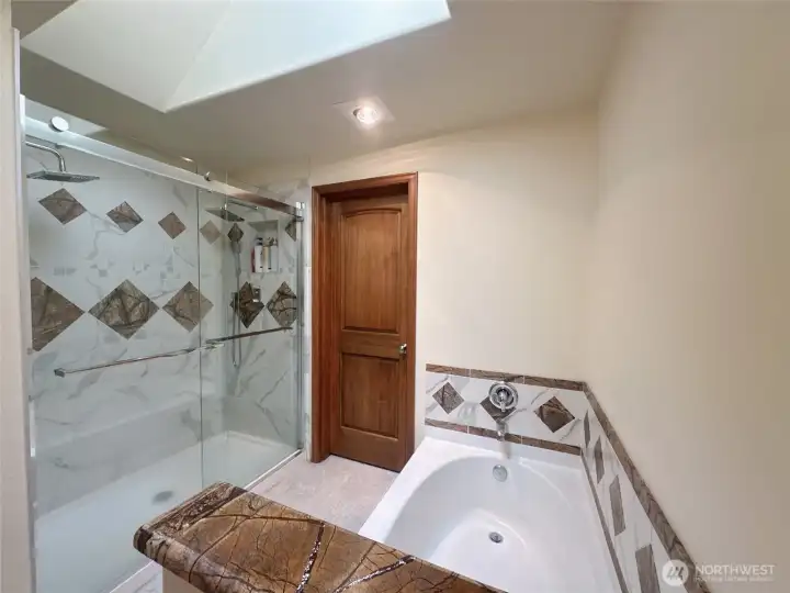 master bathroom with two shower head and deep bath tub