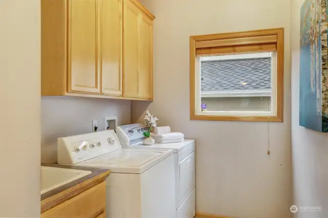 The dedicated laundry room provides efficiency with ample cabinetry, counter space, and a utility sink. A large window allows for natural light, making household chores a breeze.