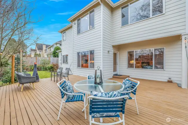 A spacious wooden deck extends from the home, providing a perfect space for entertaining or relaxing in a private backyard setting.