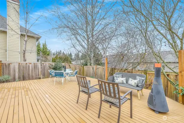 Capturing a wider perspective, this image highlights the deck’s seamless connection to the home and its integration into the well-maintained backyard.