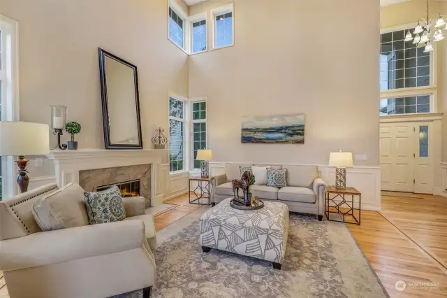 Enjoy the elegance of this open living space, where the grand staircase serves as a stunning backdrop. The high ceilings and tall windows enhance the sense of space, making the home feel both luxurious and inviting.