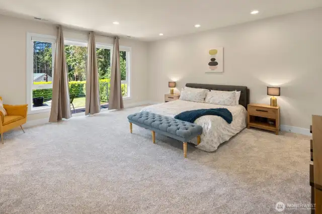 Upstairs, the sumptuous primary suite is sized for even the largest furniture, and the private deck overlooks the greenery outside.