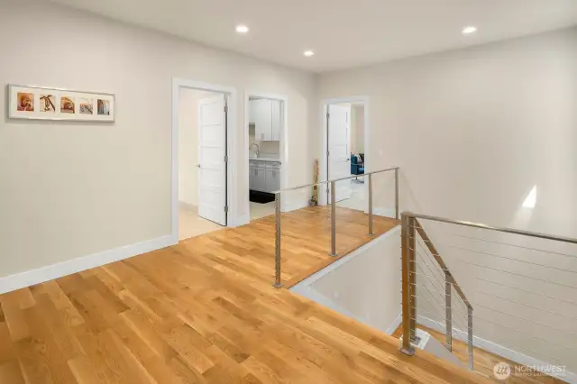 Spacious landing serves as the hub of the upper floor bedrooms, with doors leading to the laundry room and bonus room in the background.