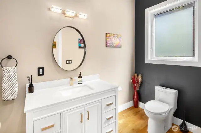 Main floor powder room, adjacent to but removed from entertaining spaces.