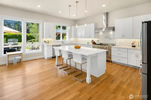 Pristine white kitchen of your dreams has tons of storage and the island becomes the ultimate gathering place while the chef is in action.