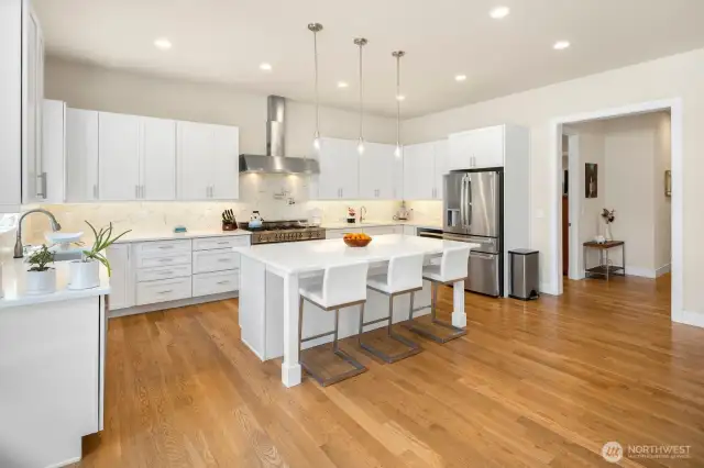 Another view of the kitchen, with the door to the guest suite and back hallway to the garage visible on the far right side of the photo.