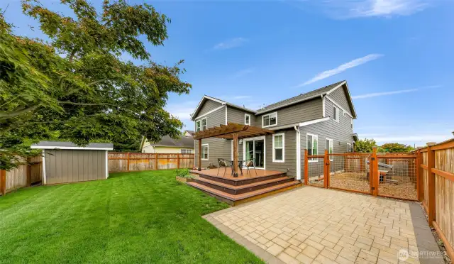 So many versatile spaces including outbuilding, patio with stone pavers, and fenced in dog run