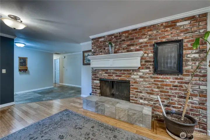 From the kitchen looking towards the entry and hallway to bedrooms standing in the secondary living space/formal dining room. Wood burning fireplace
