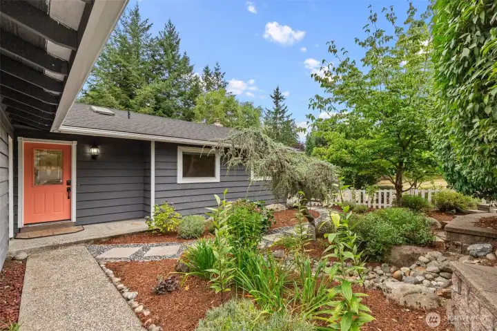 Walkway, plantings and the coral front door at the main entry.