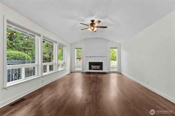 Dining side looking toward the brick fireplace and windows.