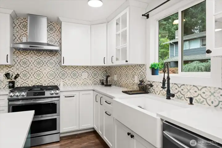 Stylish kitchen featuring farmhouse sink, stainless appliances, and designer tile backsplash.