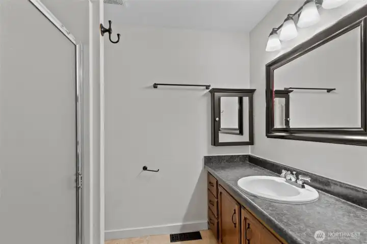 Ensuite with long vanity, framed mirror and step-in shower.