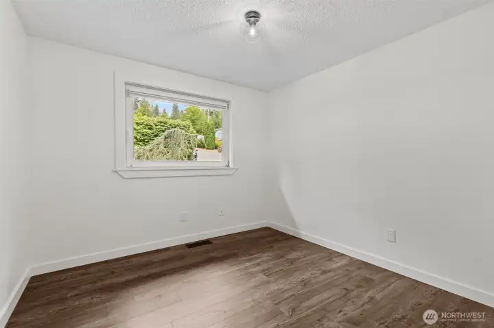 Third bedroom with new flooring and bright window.