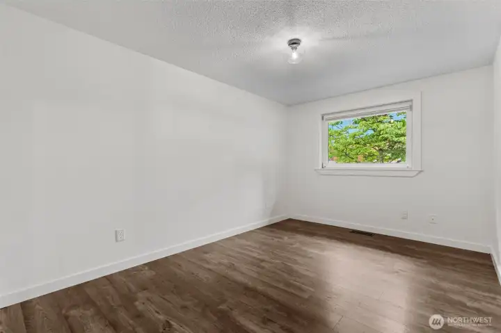 Second bedroom with window overlooking front landscaping.