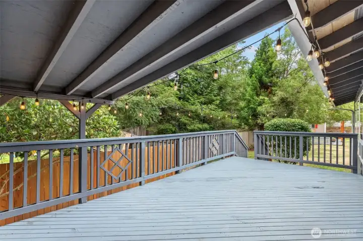 Party-ready covered deck with bistro lights and railing detail.