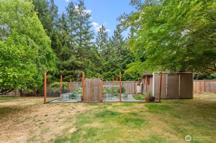Closer look at the fenced vegetable beds and gravel paths.