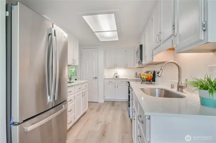 Beautiful kitchen remodel features granite counters, fresh resurfaced white cabinets, new undermount sink faucet, new SS appliances.