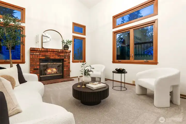 Living room with gas burning brick fireplace flanked by wood wrapped side lights.