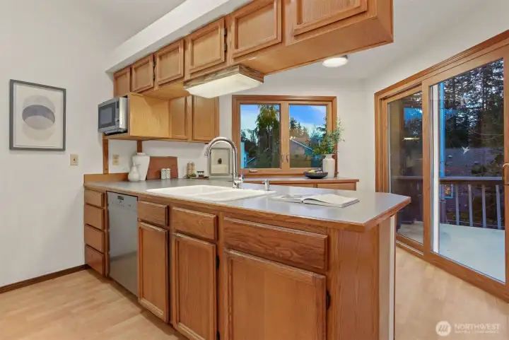 Kitchen with over sink lighting, breakfast bar, and sliders to rear sunny south facing deck.
