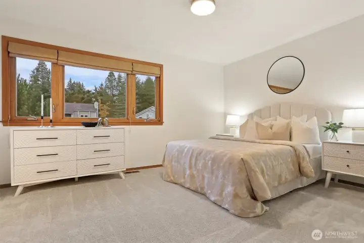 Spacious upper level primary suite with wood wrapped windows.