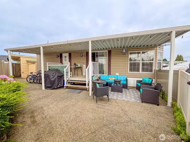 Low maintenance landscaping and covered porch and patio are a perfect place to relax