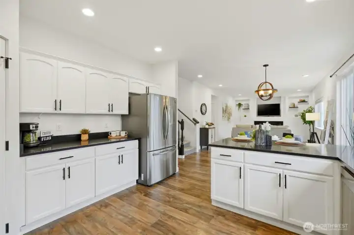 Beautifully painted white cabinets, black quartz countertops and stainless steel appliances