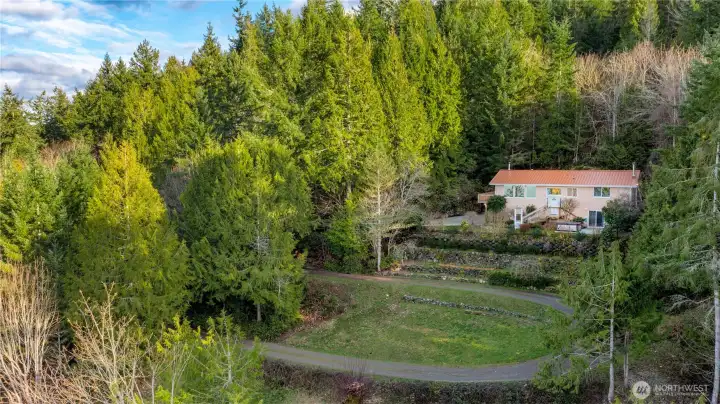 Nestled in a cloak of trees, this home sits center of the 2.77 acres which continue up the hill behind the home. Nestled in a cloak of trees, this home sits center of the 2.77 acres which continue up the hill behind the home.