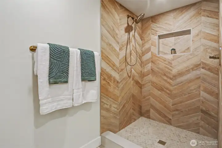 Primary walk in shower with designer tile