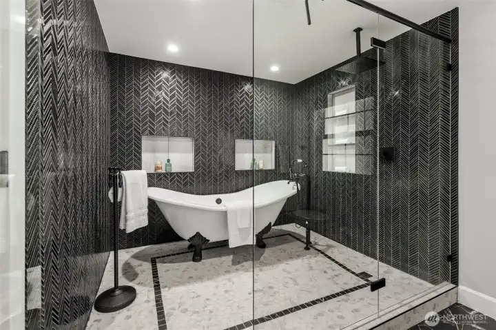 Beautiful clawfoot tub in a shower with custom glass doors