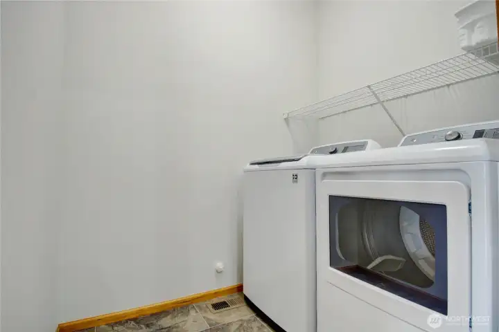 Dedicated laundry room off kitchen with extra storage space for convenience.