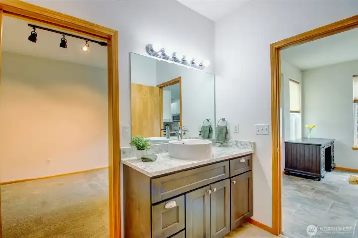 Continental style full bathroom with pocket door to second bedroom.