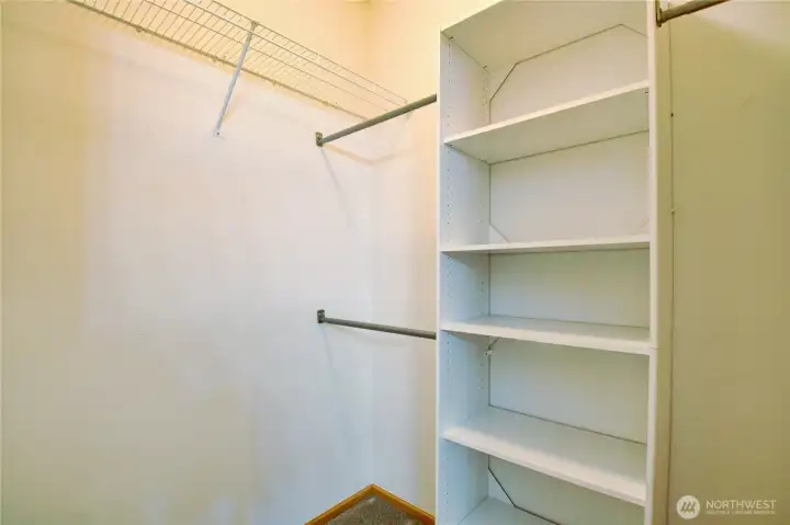 Walk in closet features custom shelving.