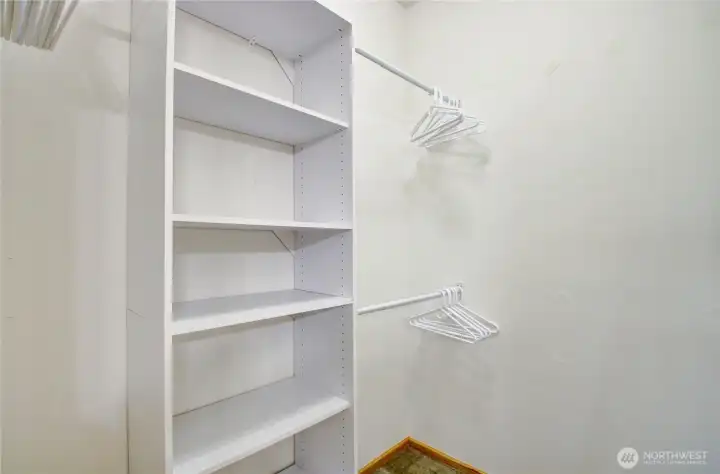Primary walk-in closet complete with custom shelving.