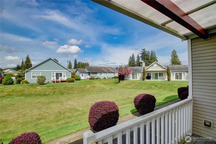 Covered back porch overlooks serene greenbelt perfect for relaxing.