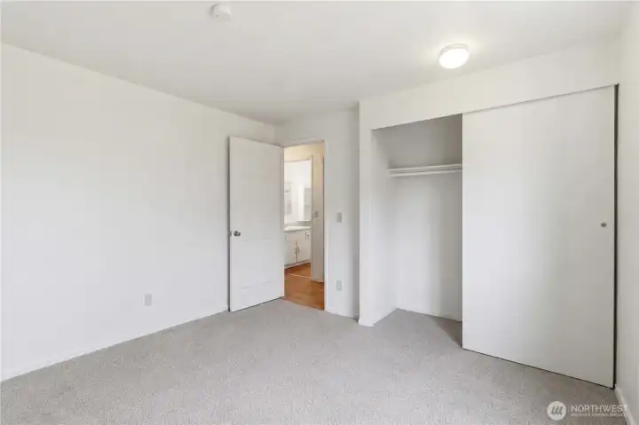 Second bedroom with a large closet and new carpet flooring