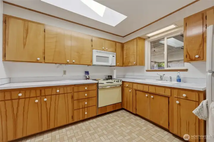 Bright kitchen features generous storage and a skylight overhead.
