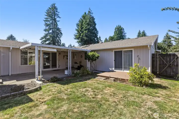 The private backyard is perfect for relaxing or entertaining, complete with a covered patio, deck, and beautifully maintained landscaping.