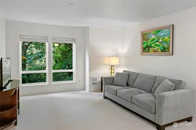 Spacious living room with view overlooking private woods.