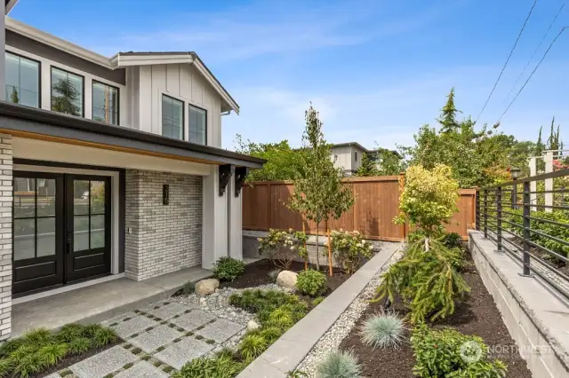 Terraced front with landscape lighting enhancing the thoughtful landscape.