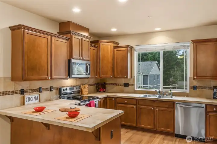 The complete kitchen has an eat bar, tiled counters and stainless appliances.