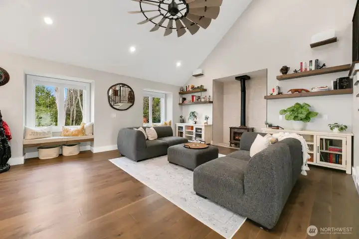 Family room off of the kitchen with floating solid wood shelves, pellet stove, and solid wood floating benches w/custom cushions in bay windows.