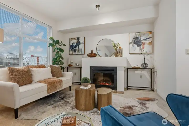 Large picture window, great ceiling height and a cozy electric fireplace make this living room warm and inviting!