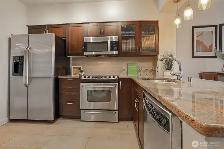 Modern kitchen features stainless steel appliances, designer hardware and granite countertops.