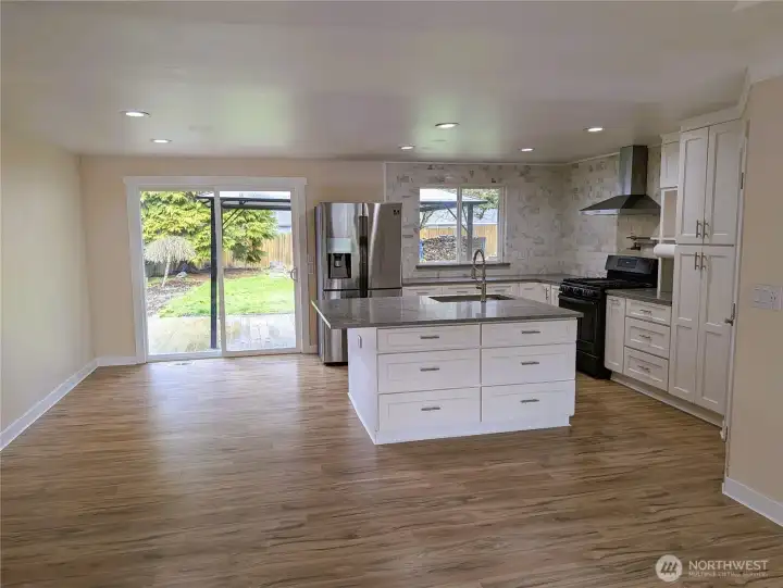 Updated & modernized kitchen with stone counter tops, large island, gas appliances, walk in pantry & pot filling faucet above the cookstove & new LVP flooring. #11823 150th St Ct E, Puyallup, WA 98374