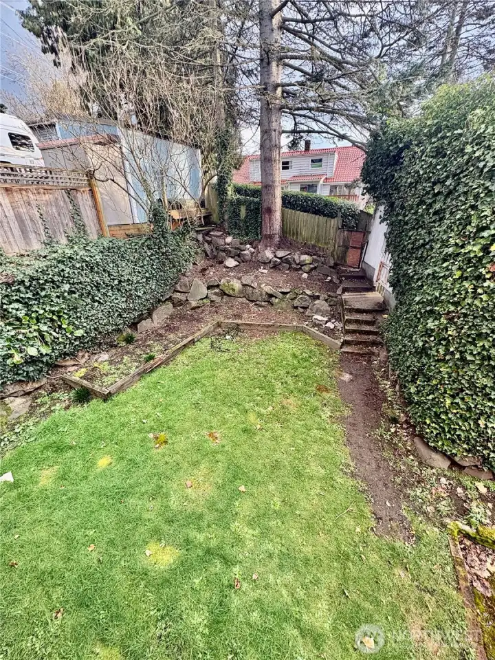 Back yard with alley access to carport.