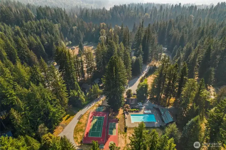 Aerial view of community pool, tennis courts, and recreation area.