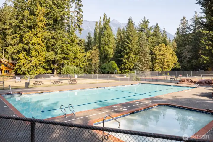 Community outdoor pool and hot tub with fenced deck area.
